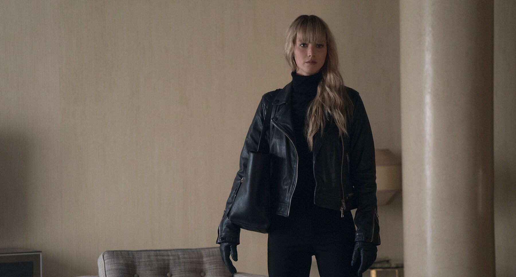 Jennifer Lawrence (as Dominika Egorova) dressed in black standing in a room in "Red Sparrow"