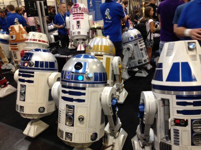 A group of R2-D2s along with other droids at a convention.