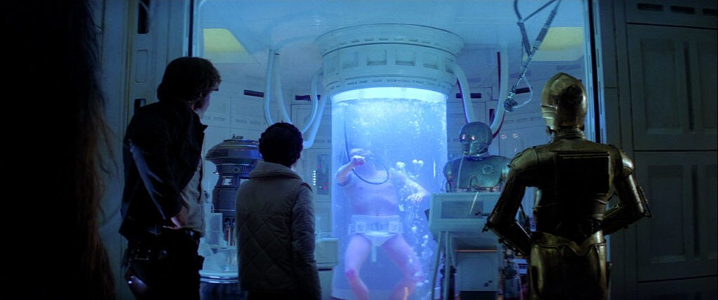 Han Solo, Princess Leia, and C-3PO watch Luke Skywalker in the Bacta Tank.