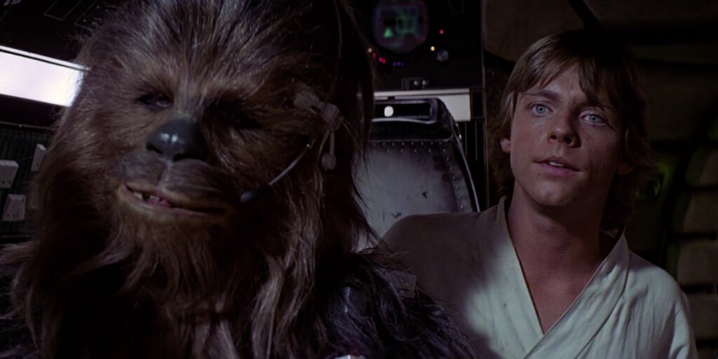 Luke and Chewie sit in the cockpit of the Millennium Falcon in A New Hope.
