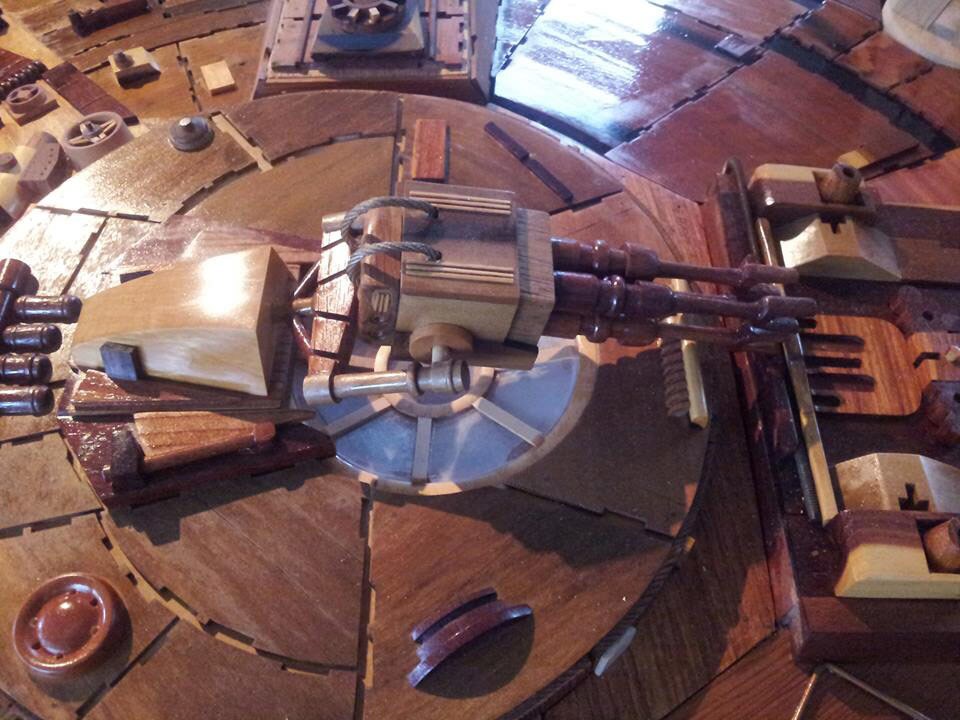 A close-up of laser cannons on the wooden Millennium Falcon sculpture.