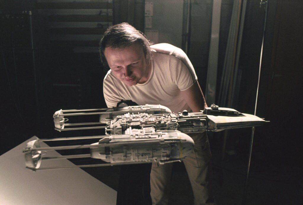 Visual effects artist Dennis Muren holds a model Rebel Alliance bomber.
