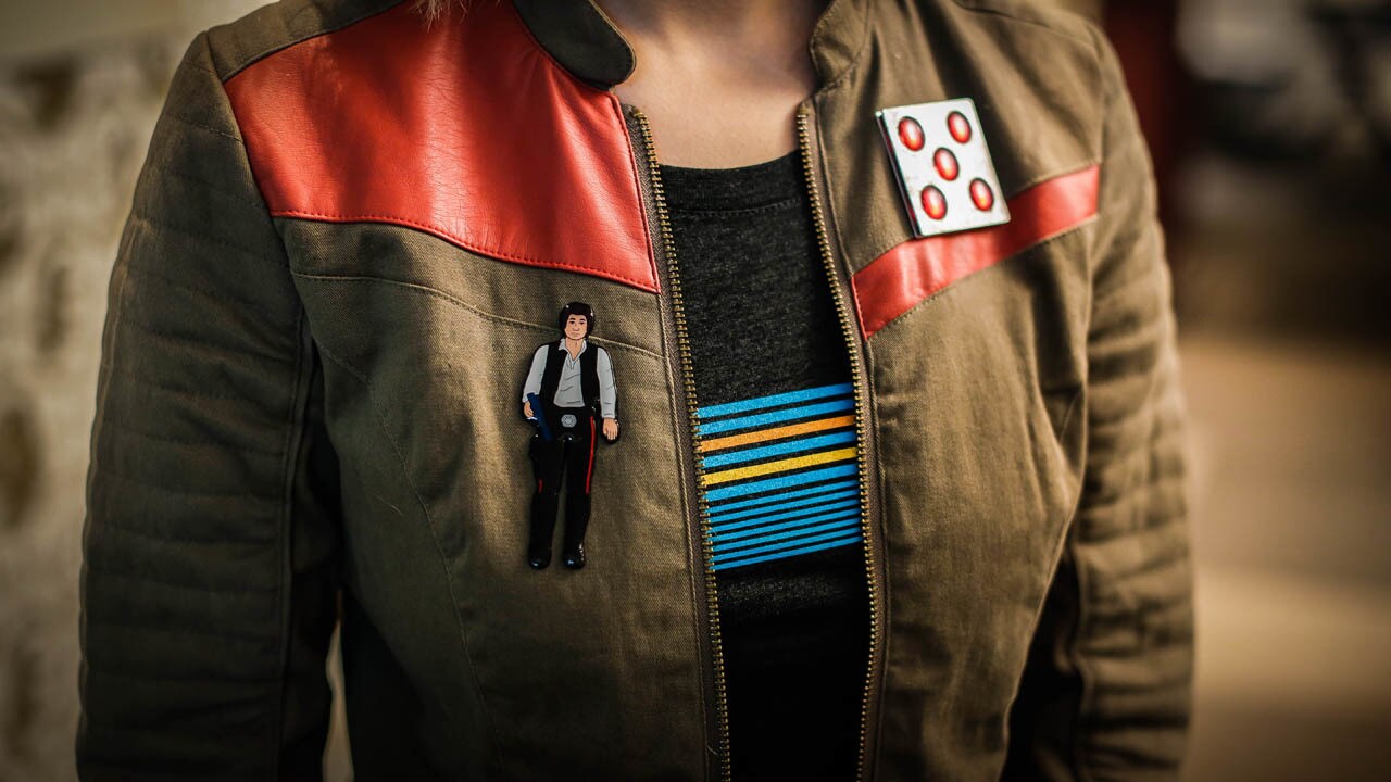 A Star Wars fan wears an enamel pin of Han Solo.