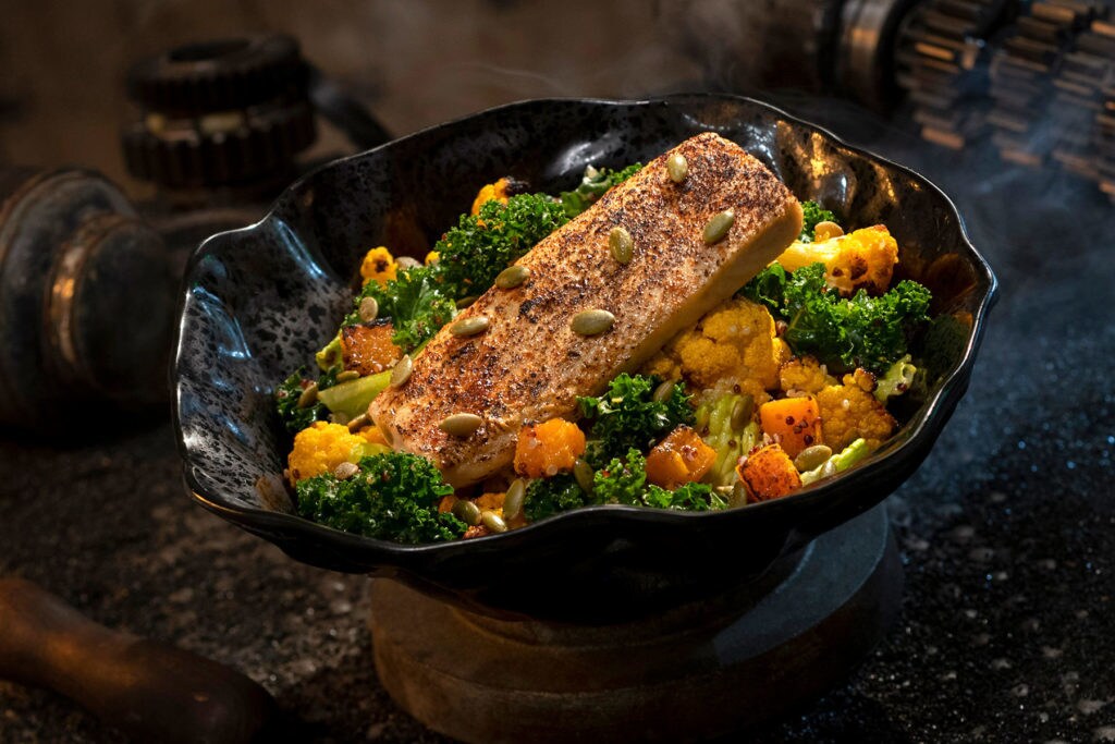 The Oven-roasted Burra Fish, found at Docking Bay 7 Food and Cargo inside Star Wars: Galaxy’s Edge, features Dijon-crusted sustainable fish with mixed greens, roasted vegetables, quinoa and pumpkin seeds with a creamy green curry ranch dressing. (David Roark/Disney Parks)