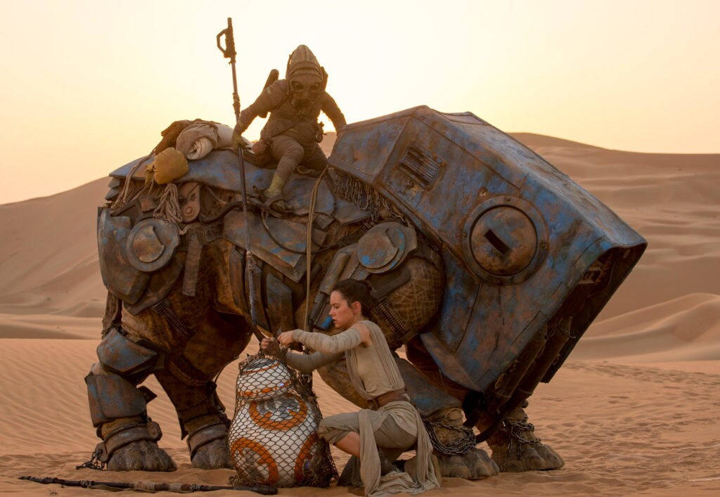 Rey reclaims BB-8 while Teedo watches her from atop his luggabeast in The Force Awakens.