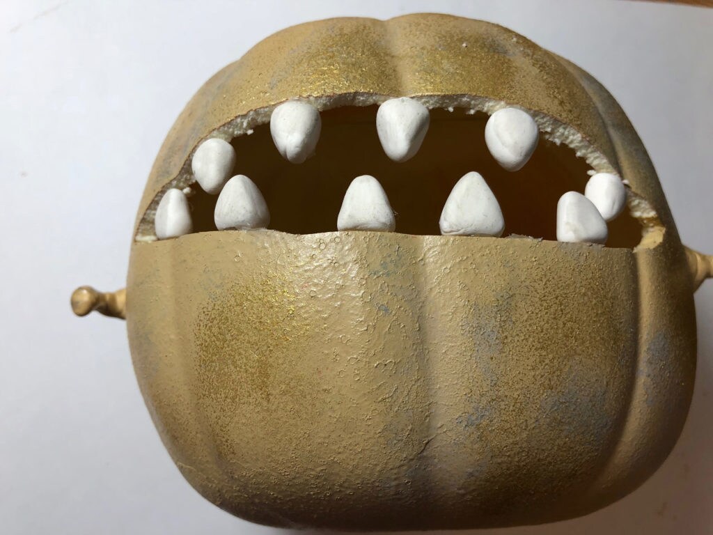 A carved pumpkin decorated to look like a toothed space slug.