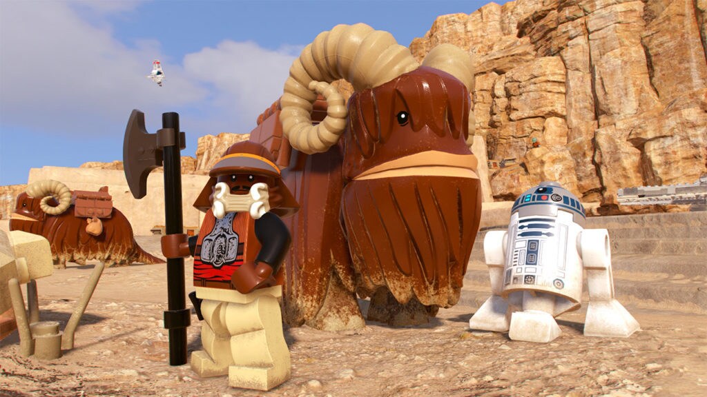 Lando in his Jabba's palace disguise with R2-D2 and a bantha in LEGO Star Wars: The Skywalker Saga.