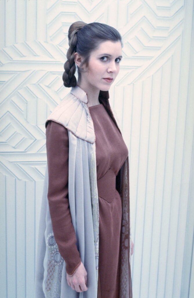 Princess Leia in a maroon tunic, pants, and paired with an embellished cloak from Star Wars: The Empire Strikes Back.