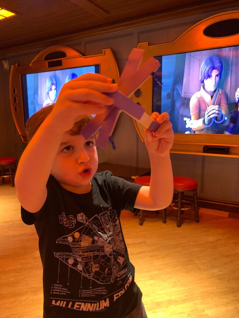 A young fan flies a craft X-wing on the Disney Fantasy during Star Wars Day at Sea.