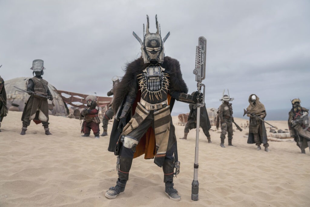 Enfys Nest stands fully masked in front of her band of pirates, the Cloud-Riders.