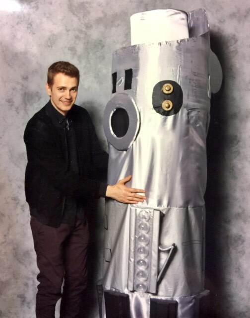 Hayden Christensen poses with a fan in a lightsaber costume.