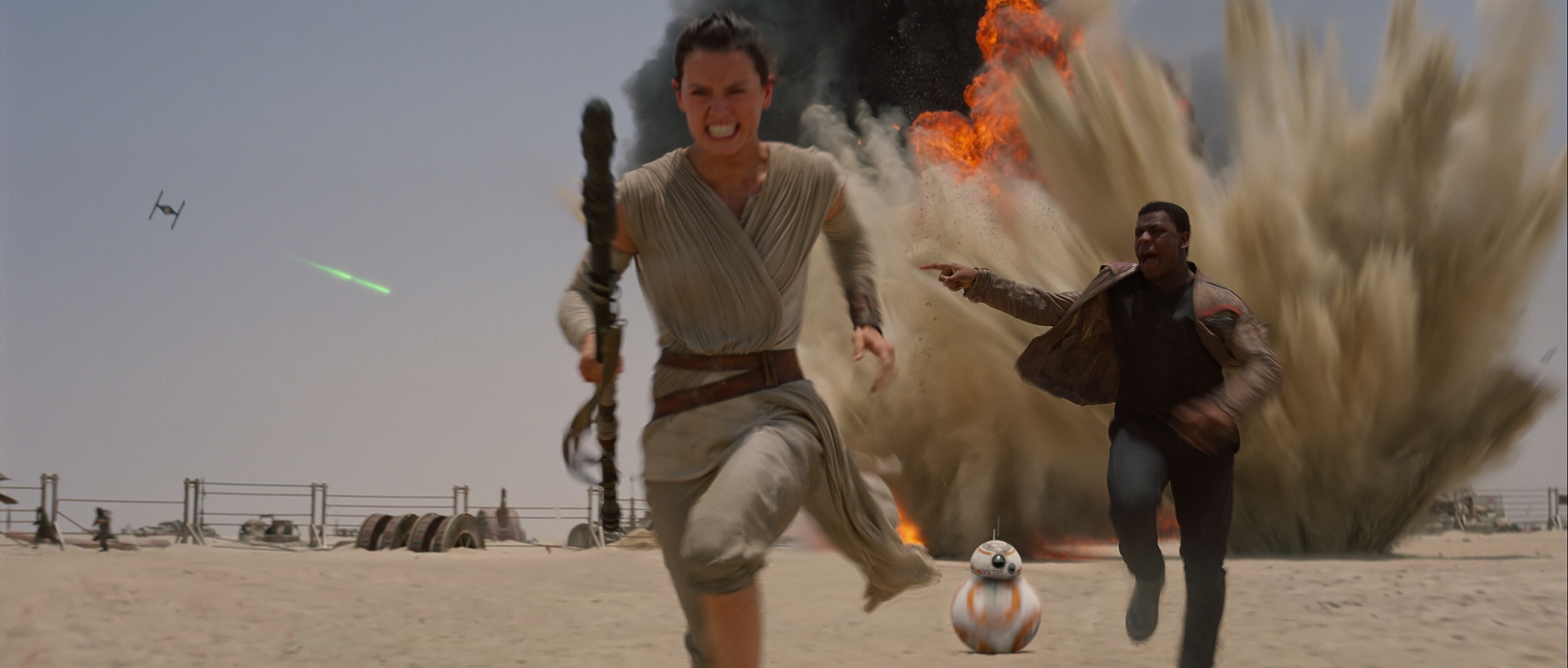 Daisy Ridley as Rey, Joh Boyega as Finn, and BB-8 on the run from First Order TIE fighters from the movie, "Star Wars: The Force Awakens."