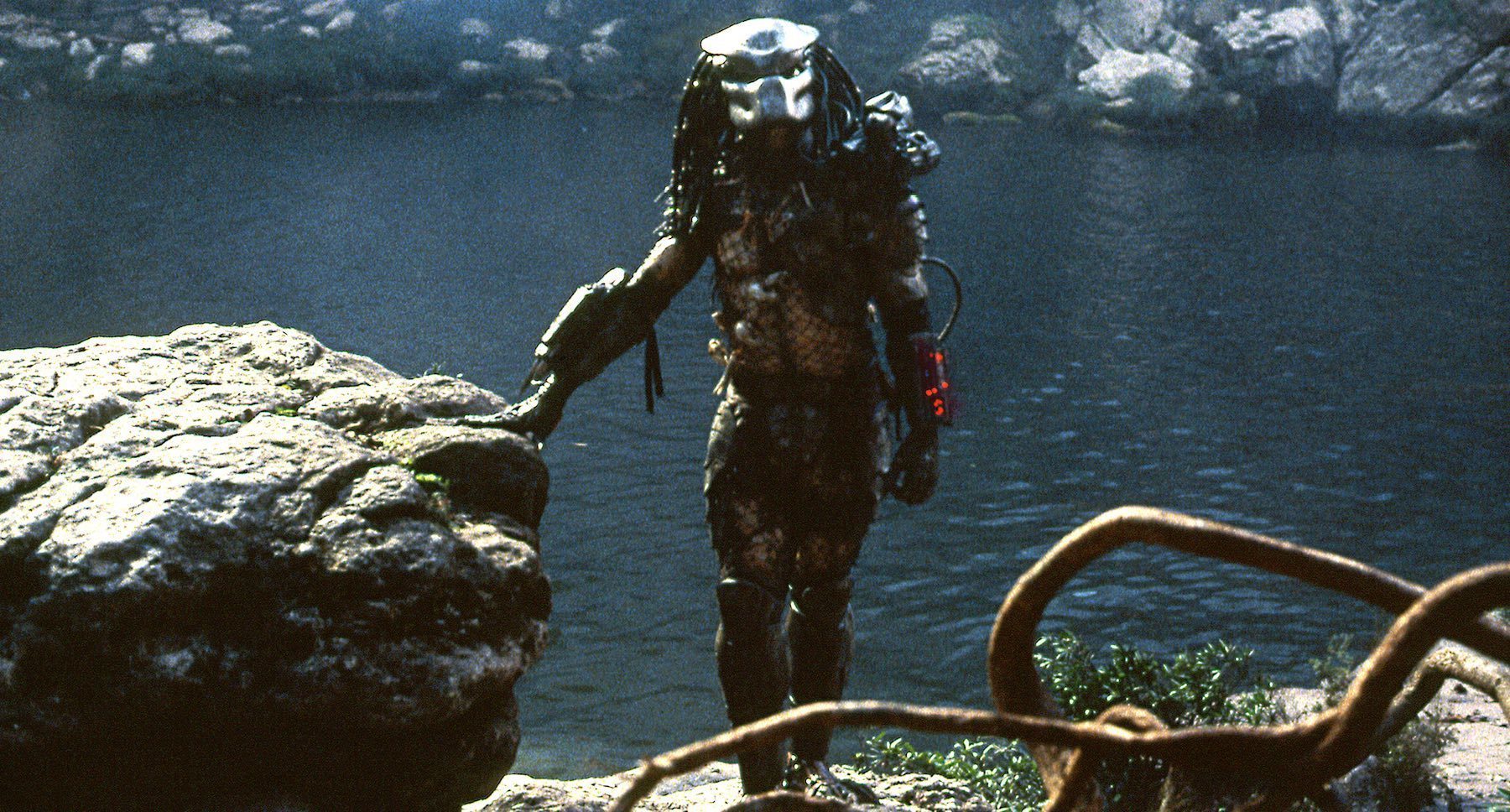 The predator standing next to a body of water in the movie "Predator"