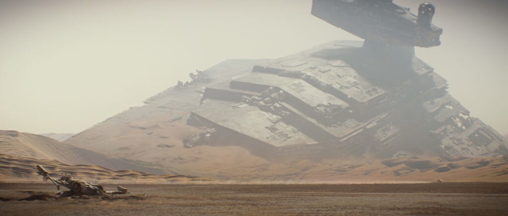 A crashed star destroyer protrudes from the sand on Jakku in The Force Awakens.