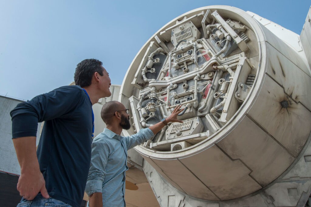 Executive Creative Director Doug Chiang and a fellow designer inspect an airlock on the Millennium Falcon seen at Disney's Star Wars: Galaxy's Edge.