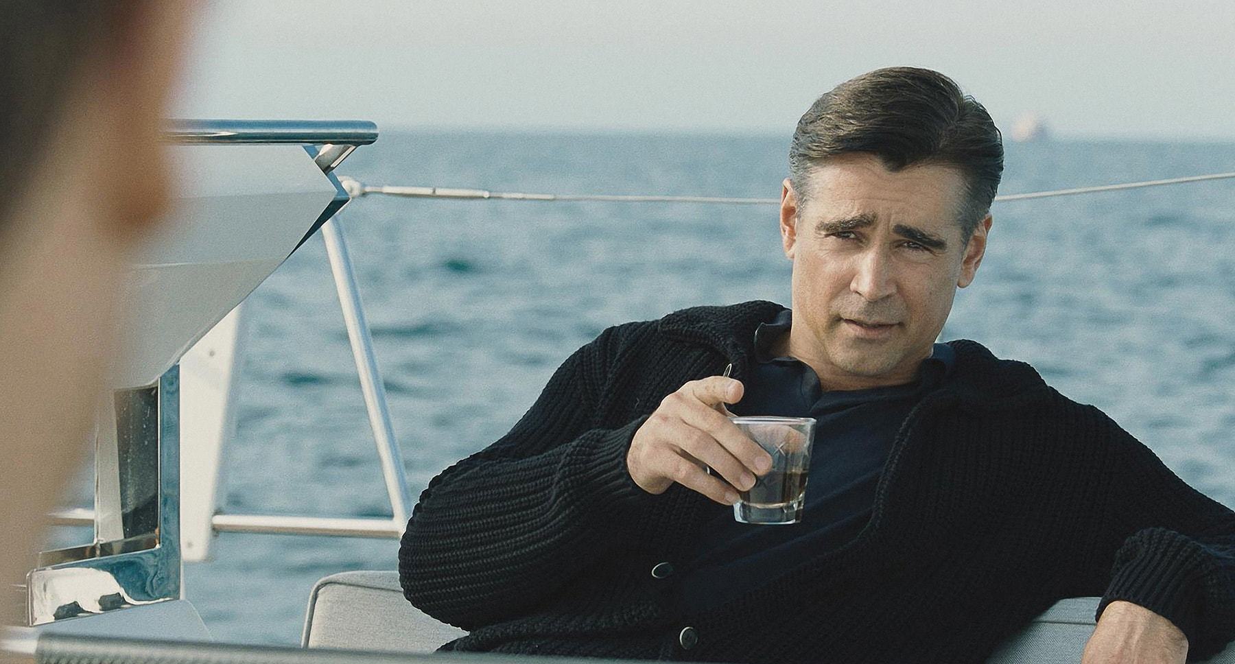 Colin Farrell with a drink on a boat in "Widows"