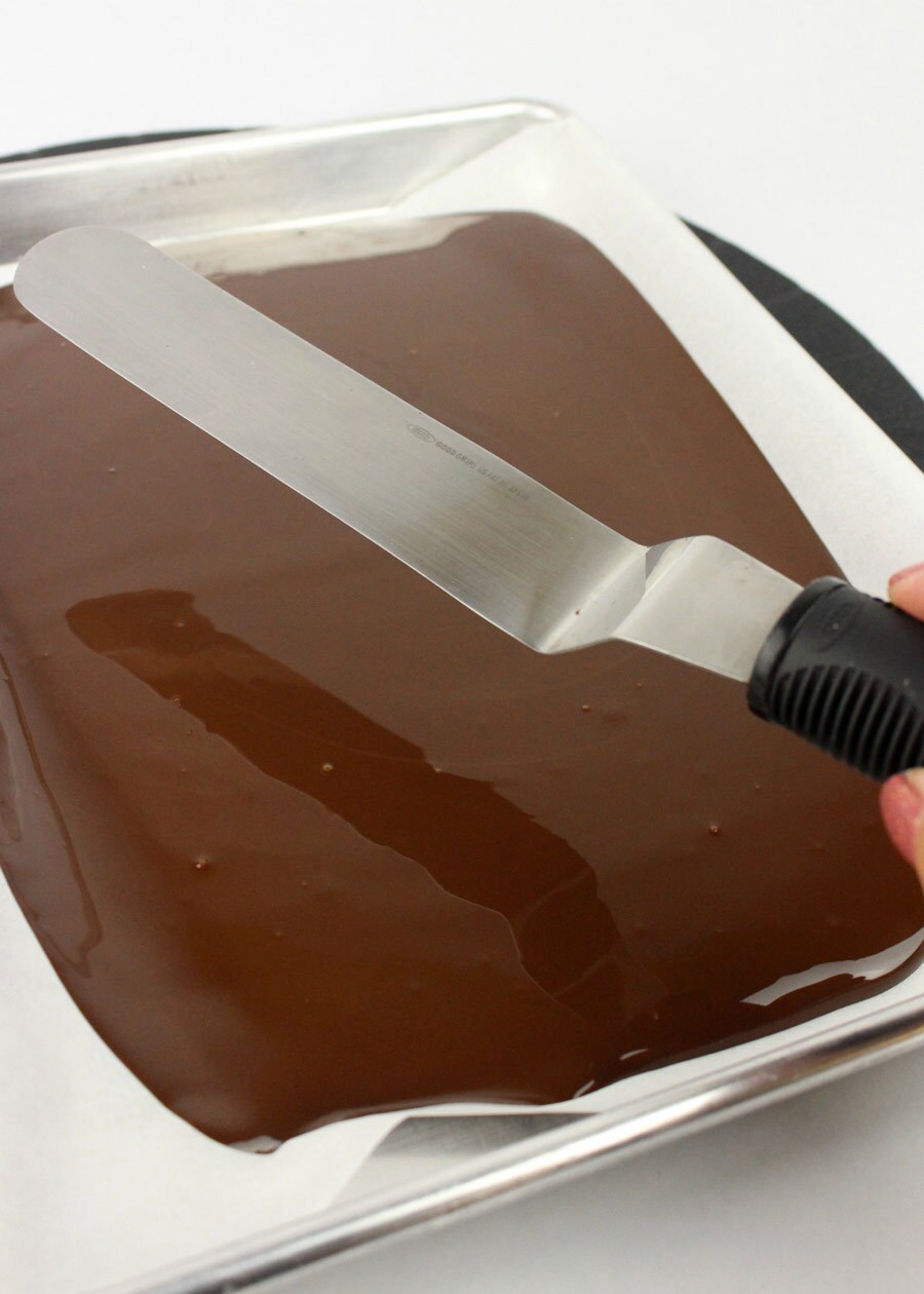 A tray of melted chocolate with a spatula.