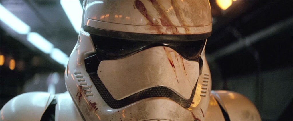 A close-up of Finn in his bloodstained First Order Imperial helmet in Star Wars: The Force Awakens.
