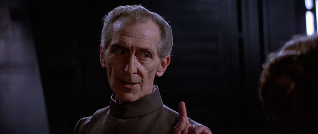 Grand Moff Tarkin holds up a finger as he speaks in A New Hope.