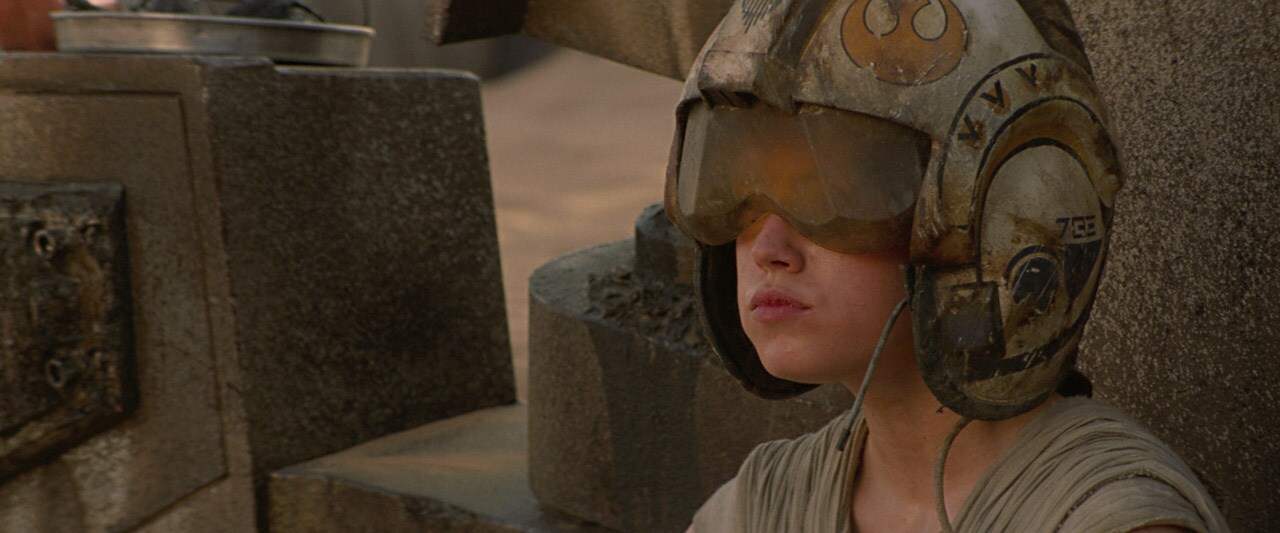 Rey wears an old, weathered Rebel pilot's helmet.