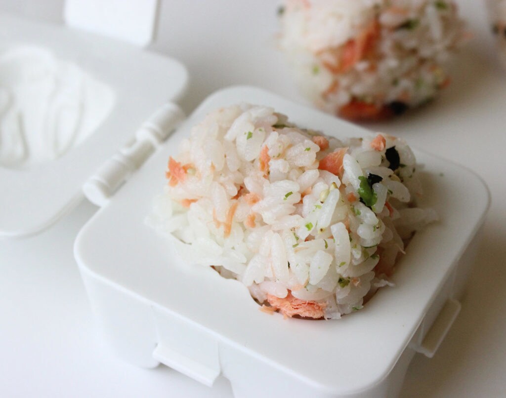 Rice and shaved salmon placed inside of a Kotobukiya stormtrooper egg shaper that forms the stormtrooper helmet.