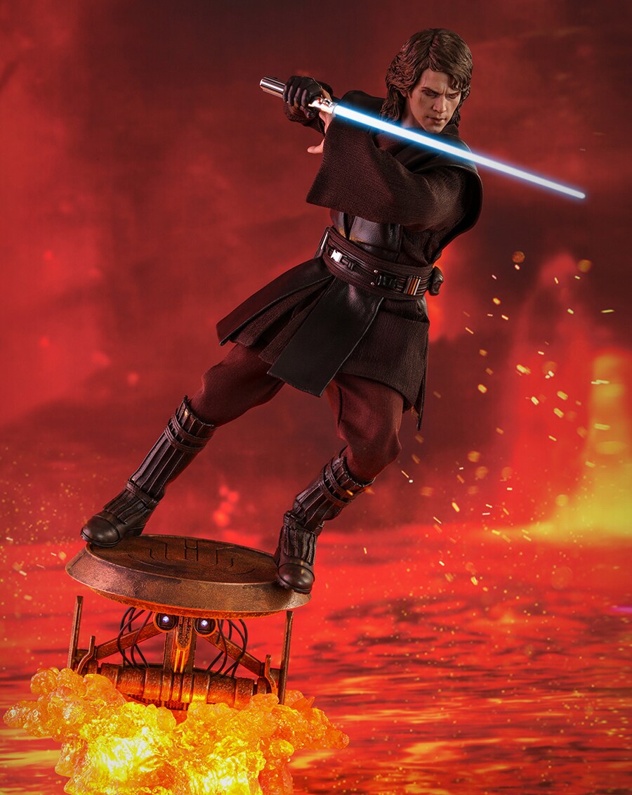 An action figure of Anakin Skywalker holding a lightsaber in the fires of Mustafar.