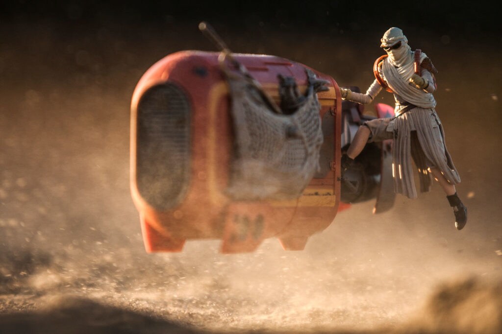 A toy Rey rides her speeder over the dirt.