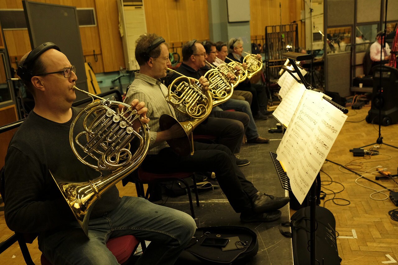 Orchestra members practice on French Horns.