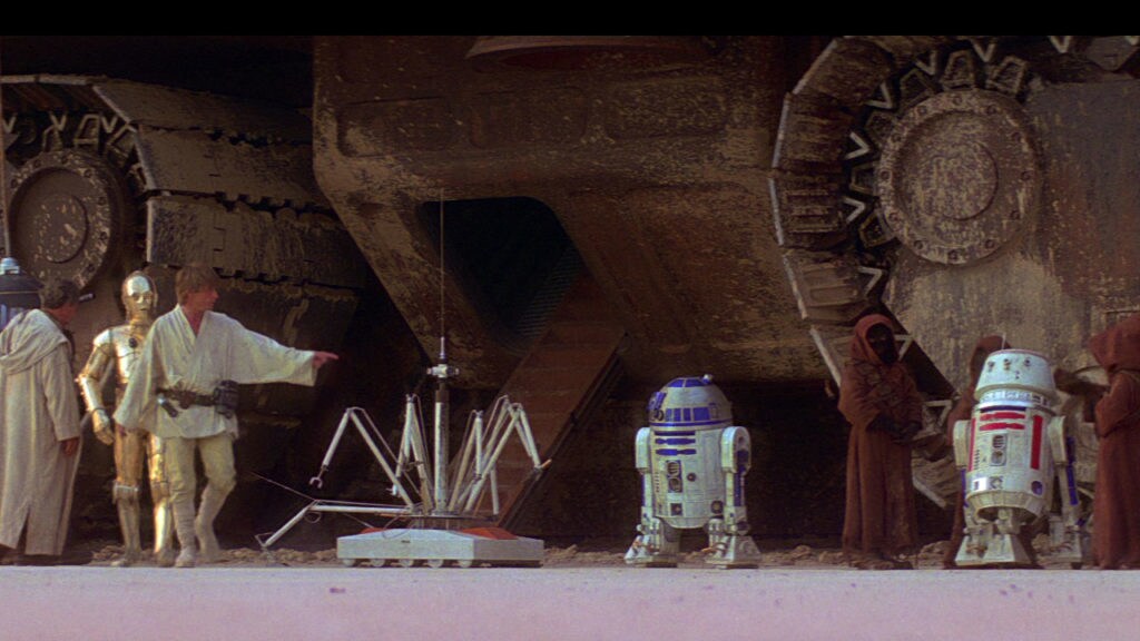 Luke meets C-3PO and R2-D2 while buying droids with his uncle.