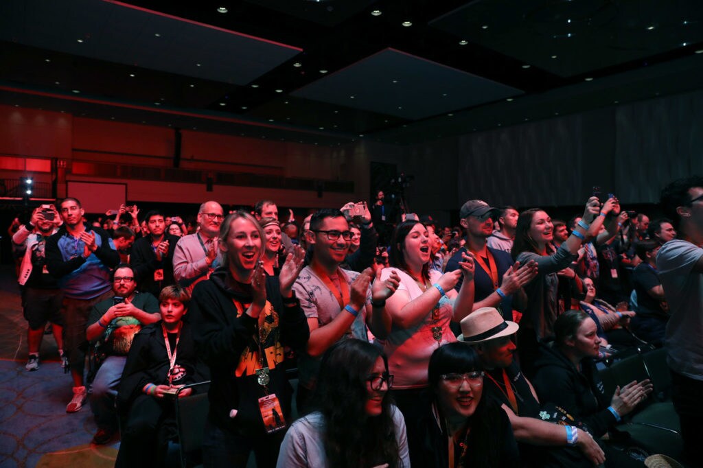 Fans stand and applaud at a Star Wars Celebration panel.