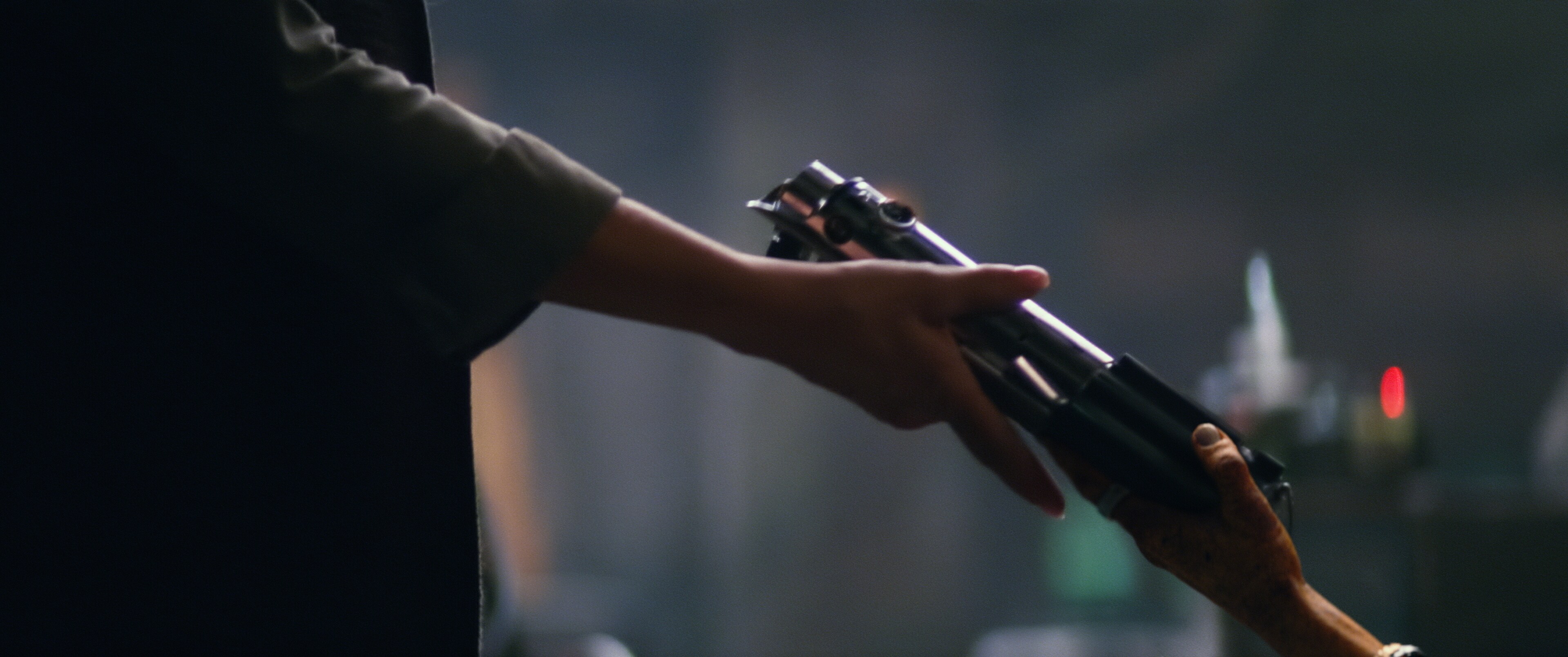 Lupita Nyong'o as Maz Kanata handing a lightsaber to Rey played by Daisy Ridley