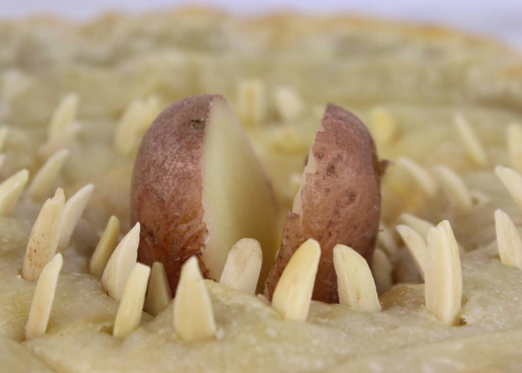 A split potato and almond slivers protrude from baked dough to give the appearance of a sarlacc's mouth and teeth.