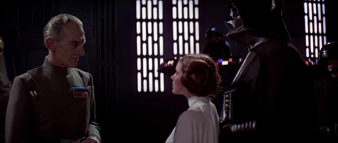 Governor Tarkin speaks to Darth Vader and Princess Leia.