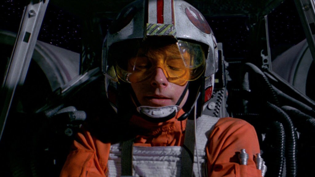 Luke Skywalker closes his eyes while flying an X-Wing starfighter.