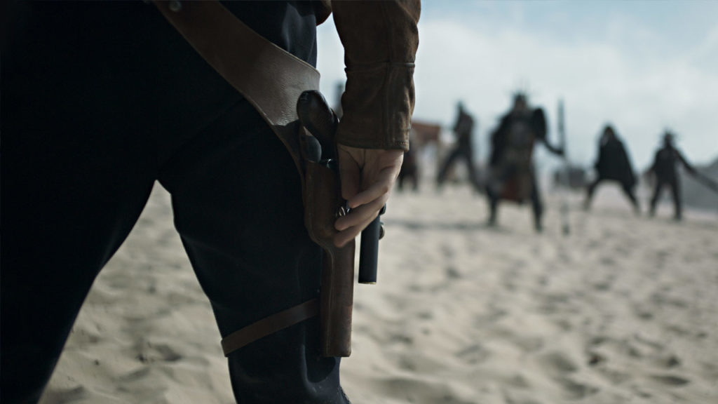 Han keeps his hand close to the holster of his blaster pistol while facing a group of enemies in Solo: A Star Wars Story.