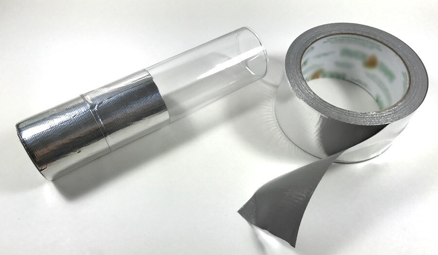 A glass bud vase and a roll of silver duct tape. Duct tape is wrapped around the bottom of the vase, to begin forming the look of a lightsaber.
