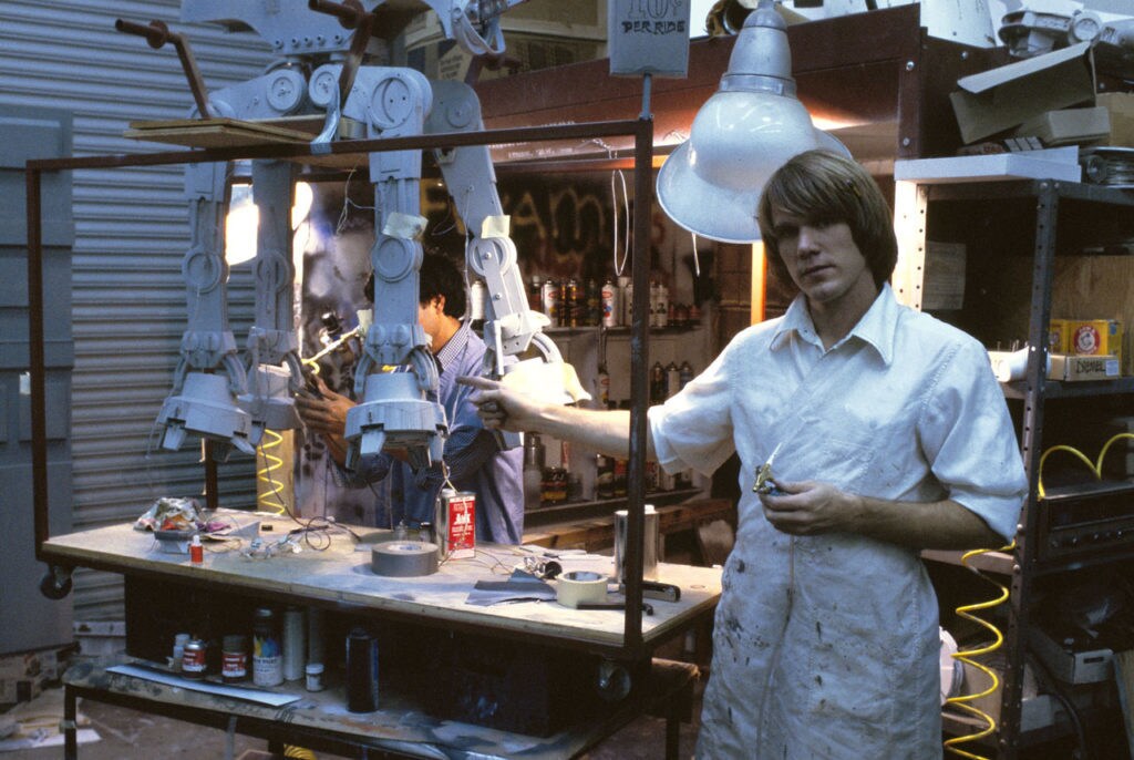 Visual effects artists work on an AT-AT model behind the scenes of The Empire Strikes Back.