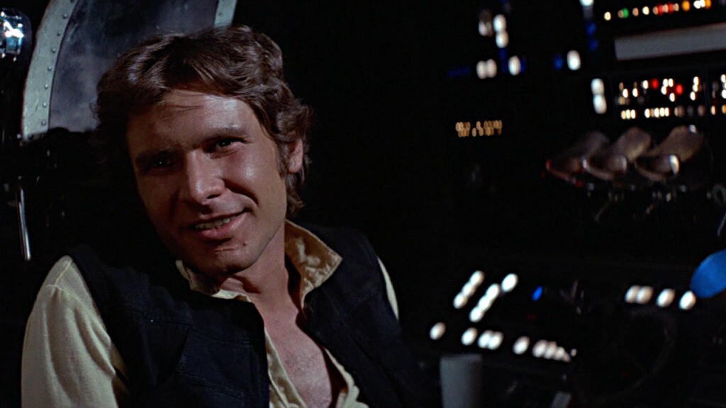 Han Solo smiles while sitting aboard the Millennium Falcon in A New Hope.