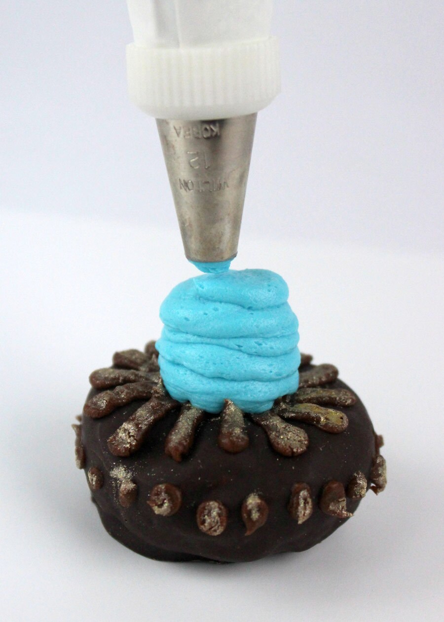 Blue frosting is piped onto the top center of the donut.