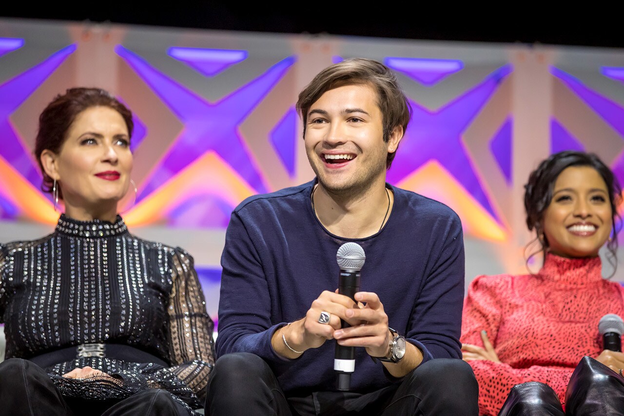 Star Wars Rebels actors Vanessa Marshall, Taylor Gray, and Tiya Sircar sit together on a couch while speaking on stage at Star Wars Celebration Chicago.