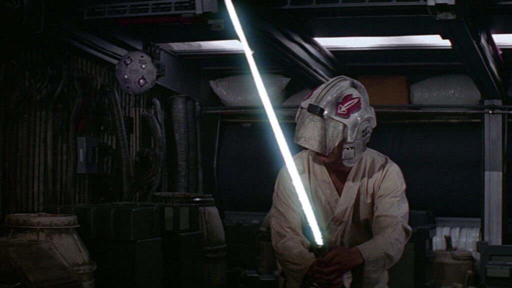 Luke Skywalker uses a lightsaber against a training droid on board the Millennium Falcon.