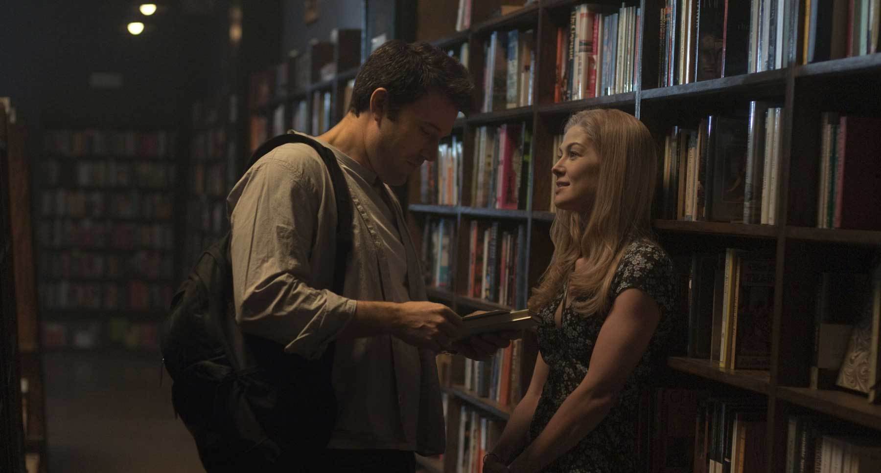 Ben Affleck (Nick) and Rosamund Pike (Amy) talking in a library in "Gone Girl"