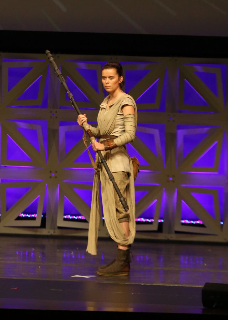 A cosplayer dressed as Rey from The Force Awakens.