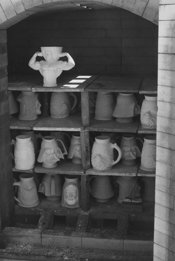 Several Star Wars tankards in a kiln, photographed in black and white.