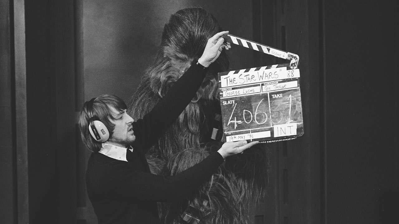 Chewbacca between takes with a crew member holding a clapboard.