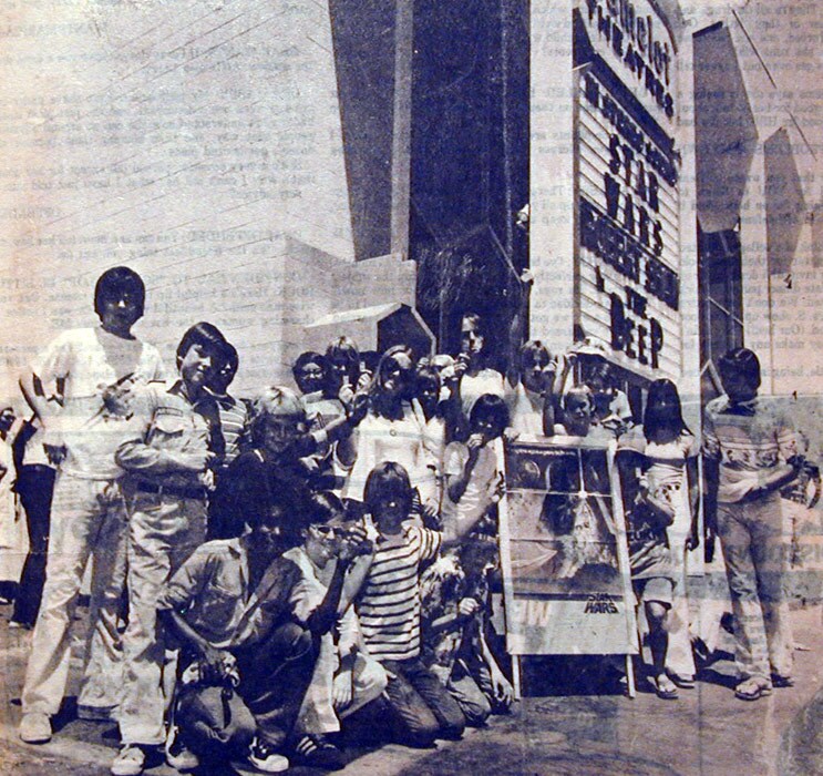 A newspaper photo of several young moviegoers posing with the 1977 Star Wars poster.