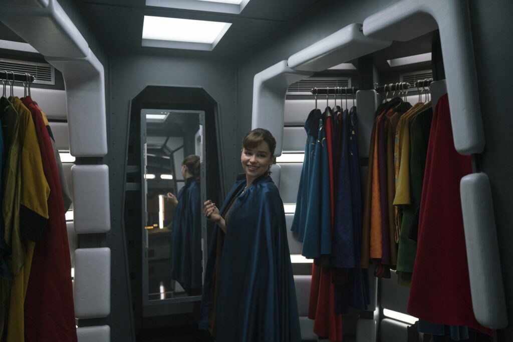 Qi'ra tries on capes from Lando Calrissian's wardrobe.
