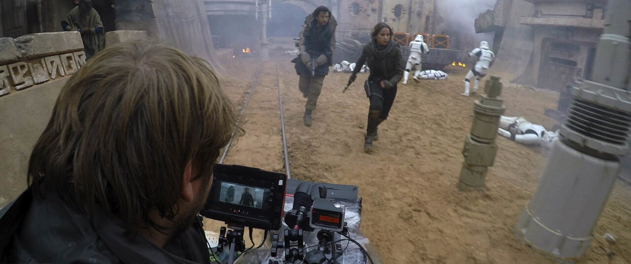 Director Gareth Edwards filming Diego Luna (Cassian Andor) and Felicity Jones (Jyn Erso) Behind the Scenes on set of a battle scene during production. 