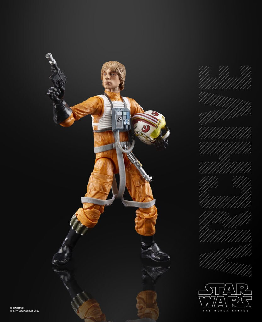 A Luke Skywalker action figure in Rebel pilot gear wields a blaster pistol.