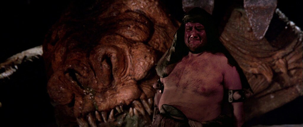Malakili, a human caretaker of animals, weeps for Pateesa, the deceased rancor from Star Wars: Return of the Jedi.